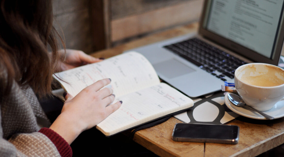 woman reading and next to laptop