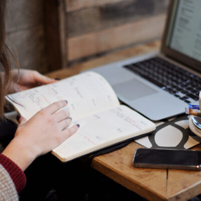 woman reading and next to laptop