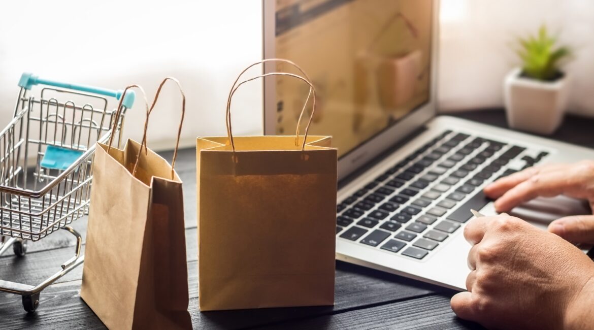 laptop on desk with paper bags