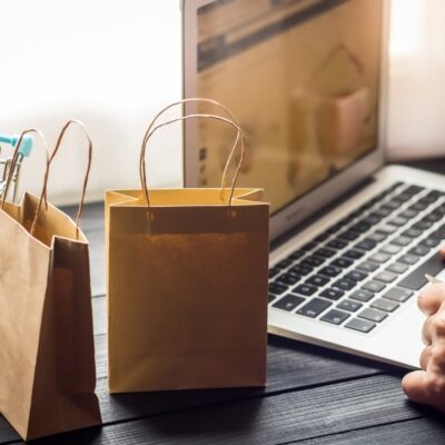 laptop on desk with paper bags