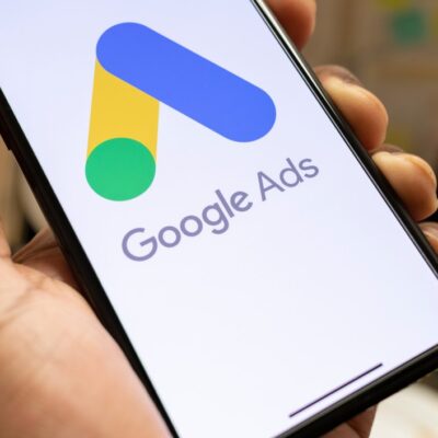 Man holding phone with google ads on screen