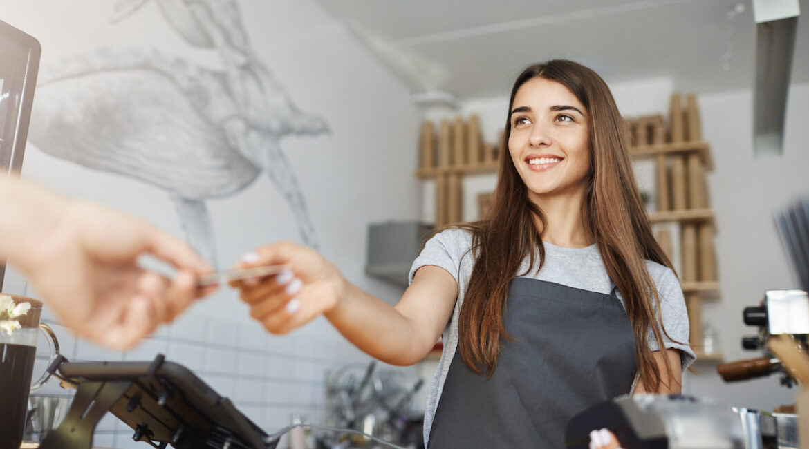 Female cashier accepting credit card from customer