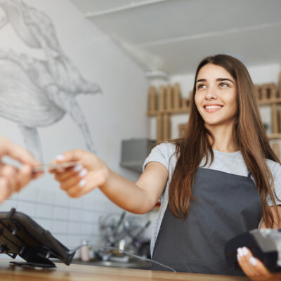 Female cashier accepting credit card from customer