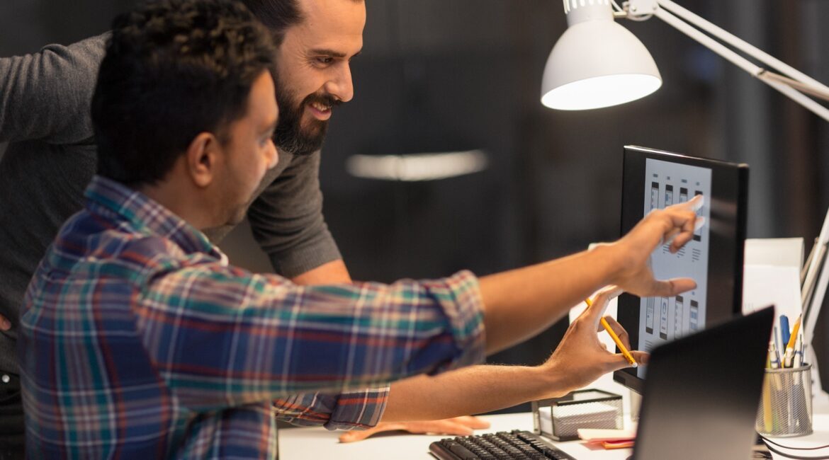 Two marketers looking at computers to analyze ads