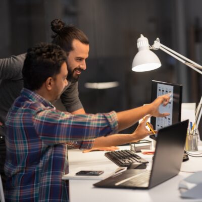 Two marketers looking at computers to analyze ads