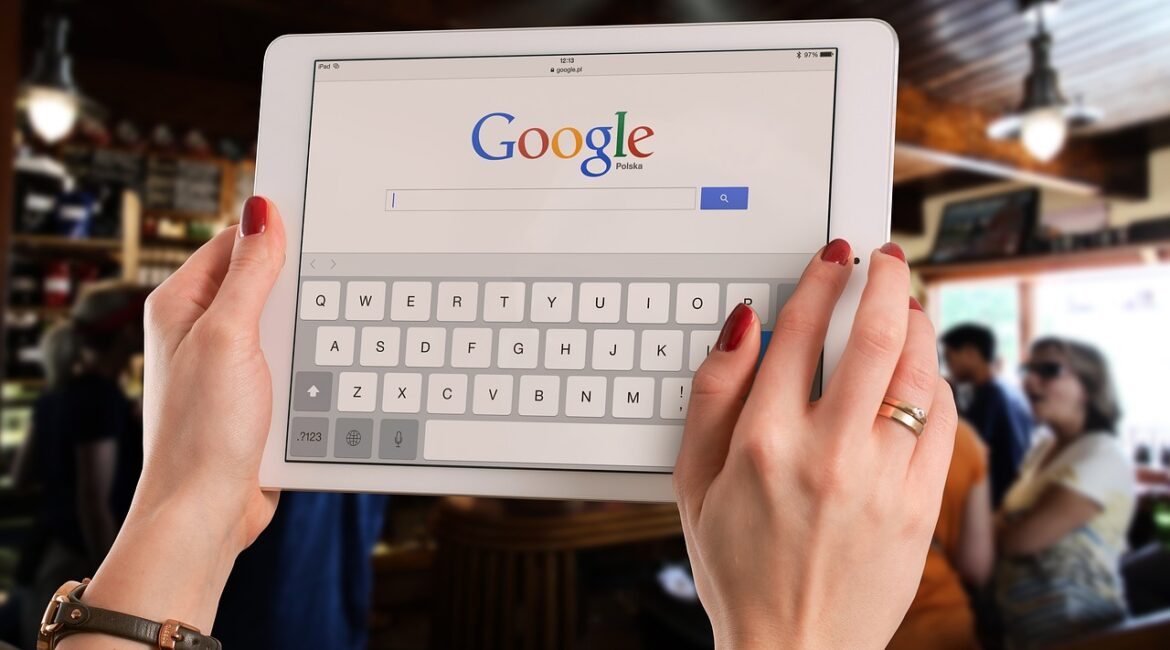 Google search homepage displayed on a tabletheld by a business owner checking their Google Ads.